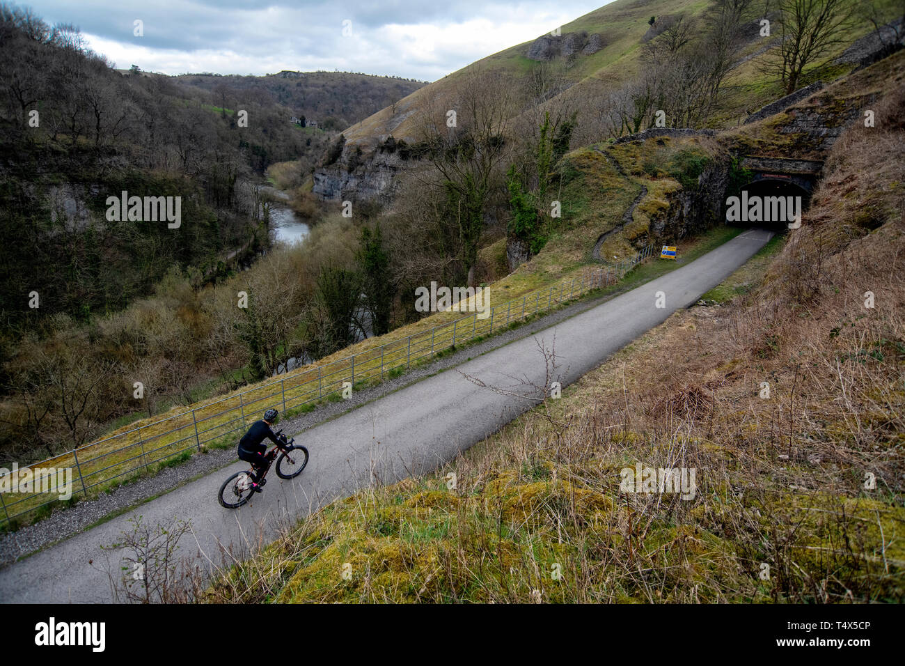 Un homme monte un vélo le long des sentiers Monsal dans le Derbyshire Peak District. Banque D'Images