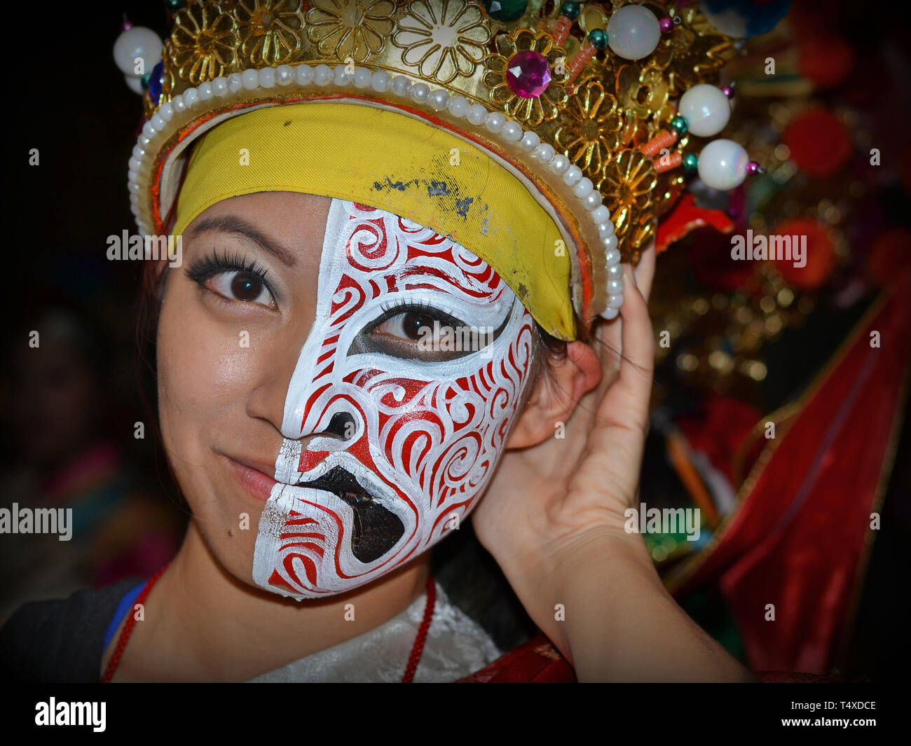 Jeune danseuse taïwanaise a la moitié de son visage peint avec un masque d'opéra de Pékin et l'autre moitié tout simplement. Banque D'Images