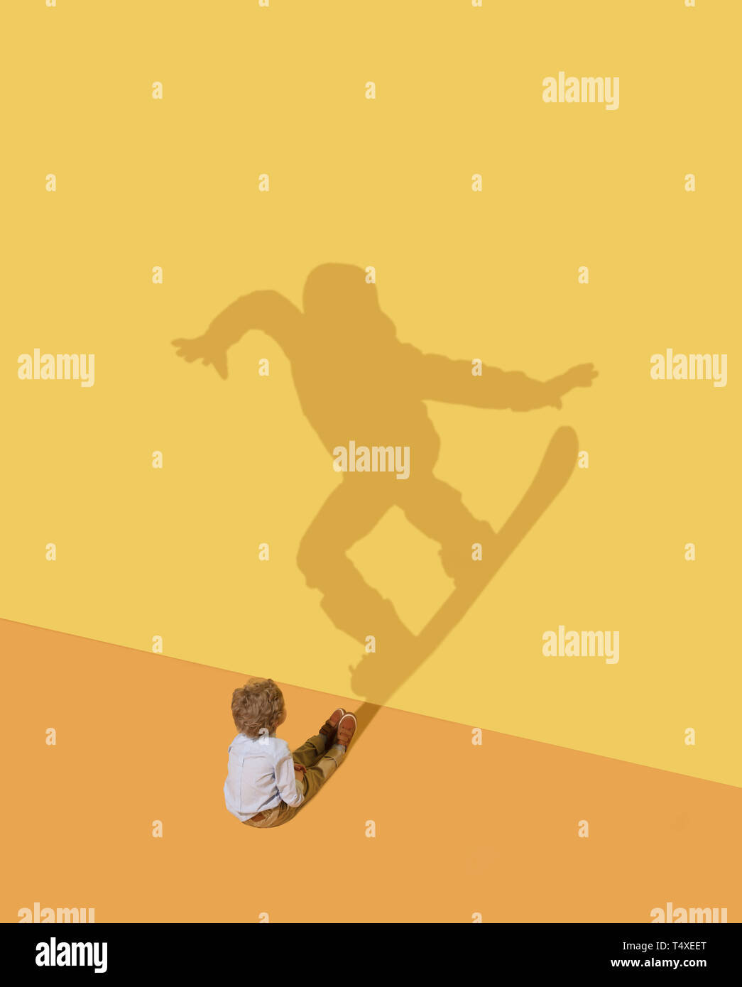 Truc fantastique. Comme un oiseau. L'enfance et de l'dream concept. Image conceptuelle avec l'enfant et de l'ombre jaune sur le mur de studio. Petit garçon veulent devenir snowboard grande sportive, champion, gagnant. Banque D'Images