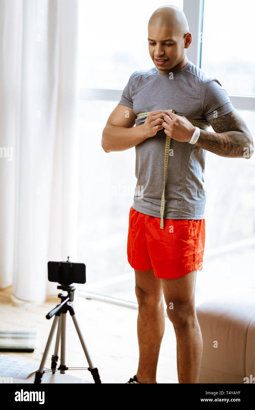 Sportsman mesurer sa poitrine lors d'un tournage vidéo sur le culturisme Banque D'Images