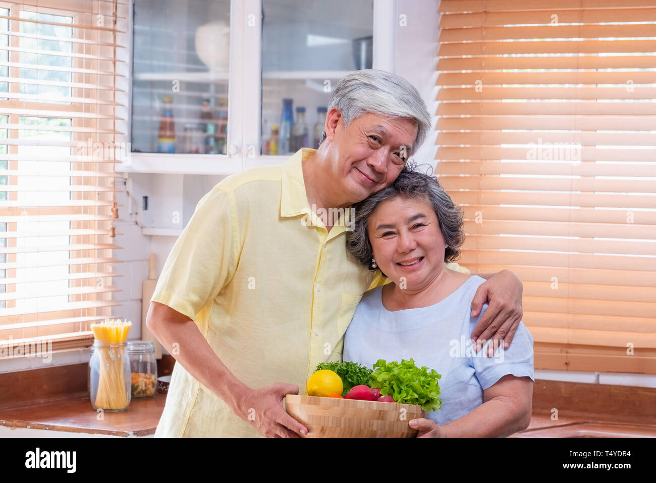 Bonheur Portrait asian senior couple en cuisine avec un bol de salade fraîche et à la caméra au vieillissement,à la maison conept. Banque D'Images