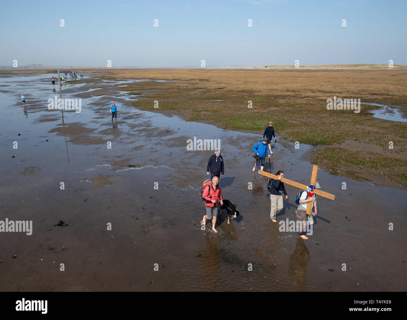 Pèlerins portant une croix à l'île sacrée de Lindisfarne dans Northumberland durant la Pâques chrétienne pèlerinage annuel, le Vendredi saint. Banque D'Images