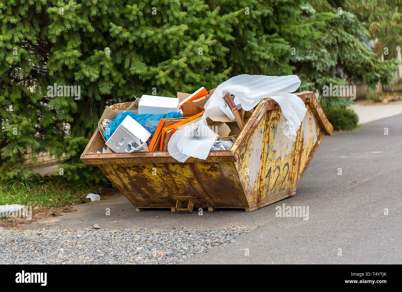 Rusty débordant récipient en métal pour les déchets de construction avec les cartons et autres déchets en plastique Banque D'Images