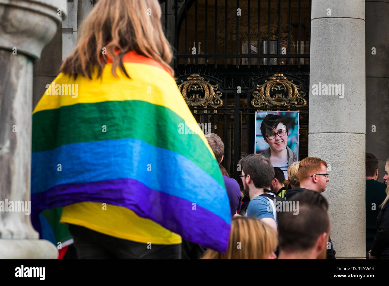 Une femme avec un drapeau arc-en-ciel à une veillée à Belfast City Hall en mémoire de journaliste assassiné Lyra McKee. Banque D'Images