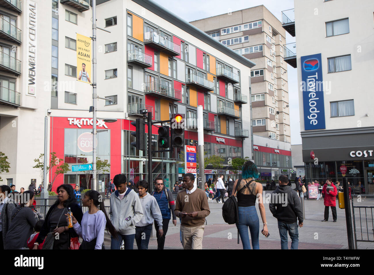 Les piétons traversant High Road, Wembley, en face d'un moderne centre de développement et de logement à Wembley Central. Banque D'Images