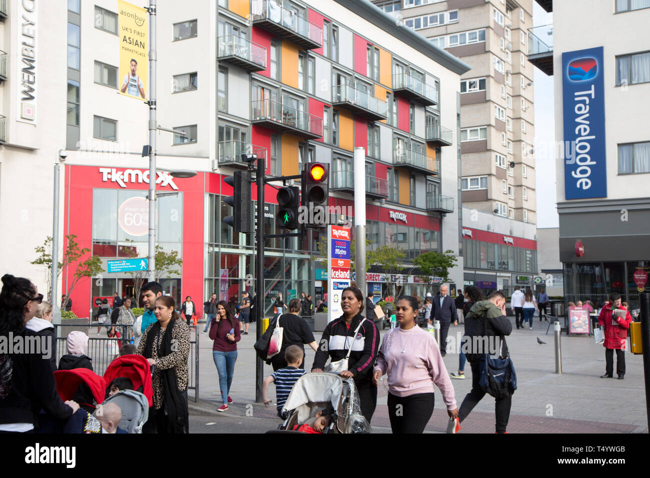 Les piétons traversant High Road, Wembley, en face d'un moderne centre de développement et de logement à Wembley Central. Banque D'Images