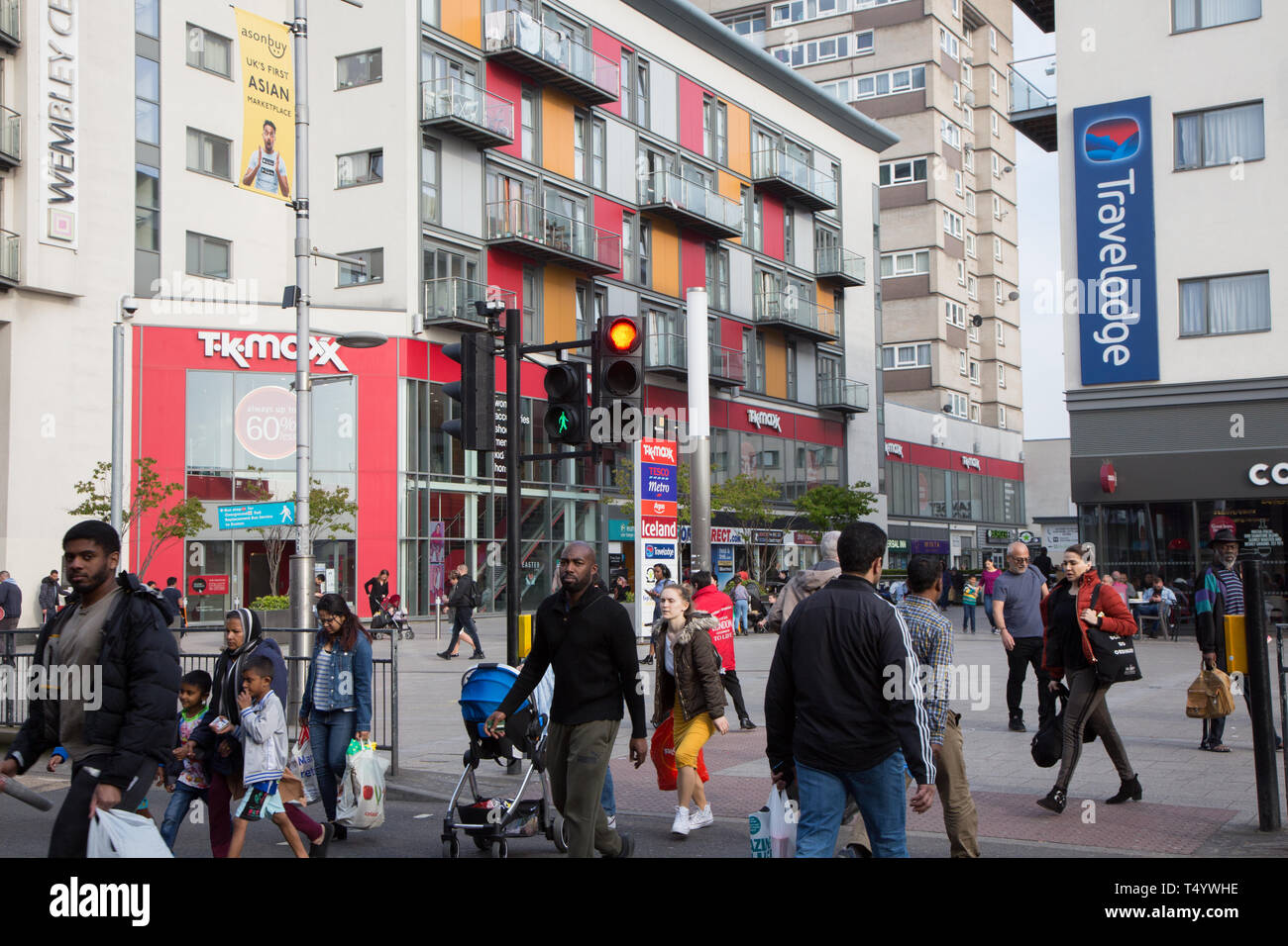 Les piétons traversant High Road, Wembley, en face d'un moderne centre de développement et de logement à Wembley Central. Banque D'Images