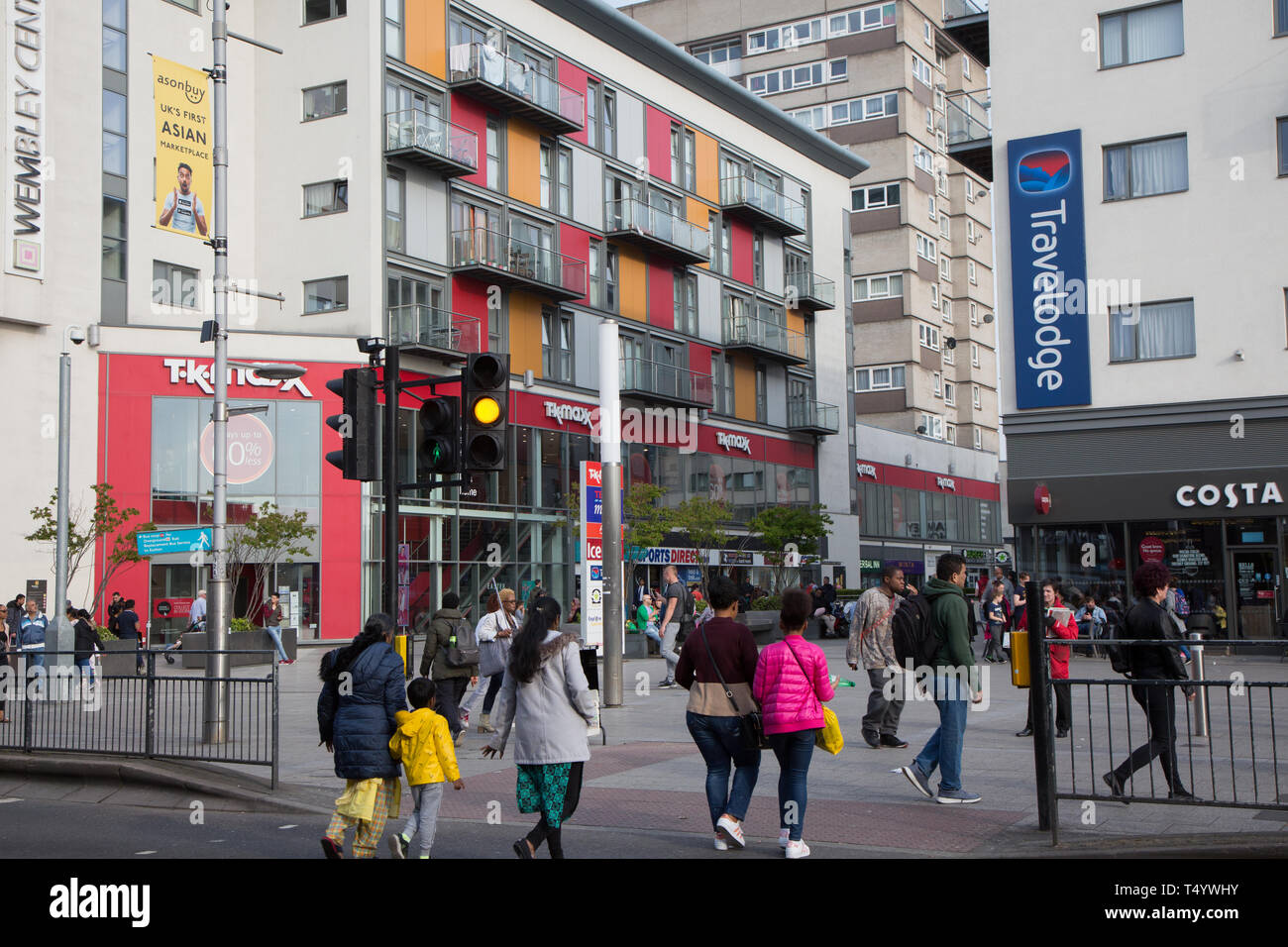 Les piétons traversant High Road, Wembley, en face d'un moderne centre de développement et de logement à Wembley Central. Banque D'Images