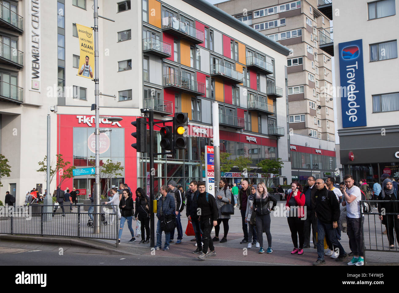 Les piétons traversant High Road, Wembley, en face d'un moderne centre de développement et de logement à Wembley Central. Banque D'Images