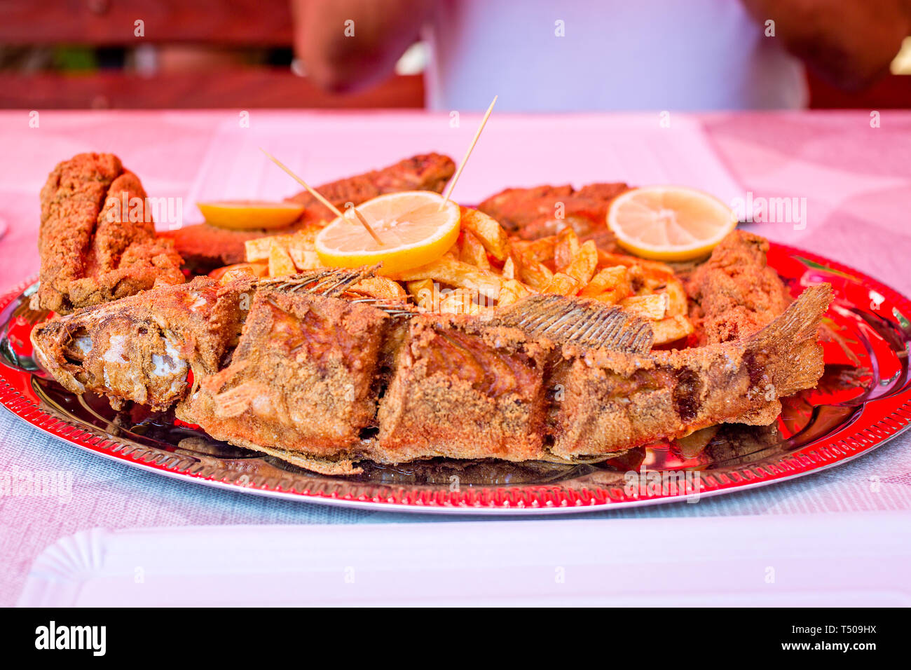 Frit délicieux de la truite et le poisson-chat pièces, frites, décoré avec des rondelles de citron sur la plaque de papier jetables. Le poisson frais de la rivière Tisza Banque D'Images