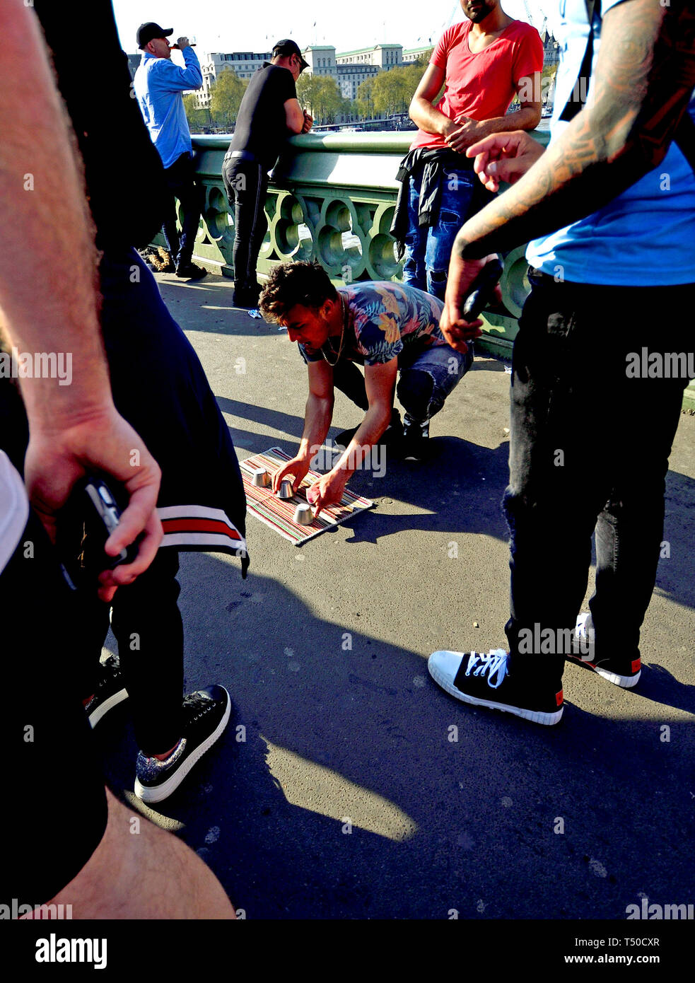 Londres, Royaume-Uni. 19 avr 2019. Sur un poste occupé le Vendredi saint jour férié, la chaussée de Westminster Bridge est presque bloqué par plus de 10 jeux illégaux de la tour ou 3 tasses tasse et ballon, conçu pour soulager les touristes de leur argent en ayant apparemment faire-valoir gagner de grosses sommes d'abord. Credit : PjrFoto/Alamy Live News Banque D'Images