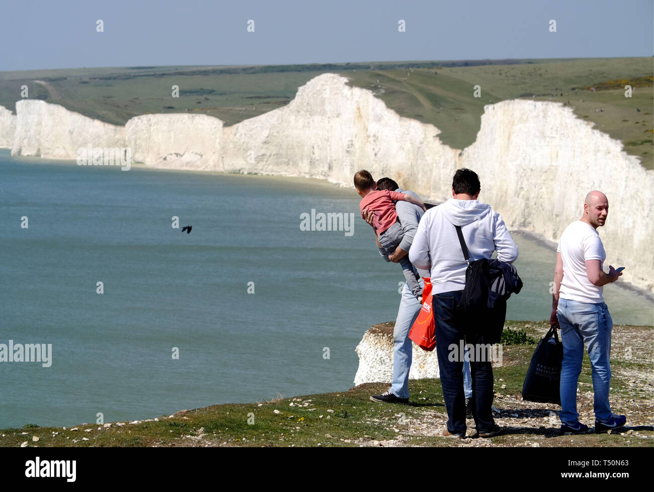 Urrugne, East Sussex, UK. 20 avril 2019. Le temps exceptionnellement doux a vu des milliers de touristes affluent à l'emblématique sept Sœurs des falaises de craie près de Eastbourne, East Sussex, dont beaucoup se selfieis dangereuses sur l'instabilité de la falaise. Un homme a été vu pendant un petit enfant dans ses bras comme il le regarda sur le vide. Les falaises sont jusqu'à 400 pieds de haut et sont un endroit bien connu le suicide. © Peter Cripps/Alamy Live News Banque D'Images