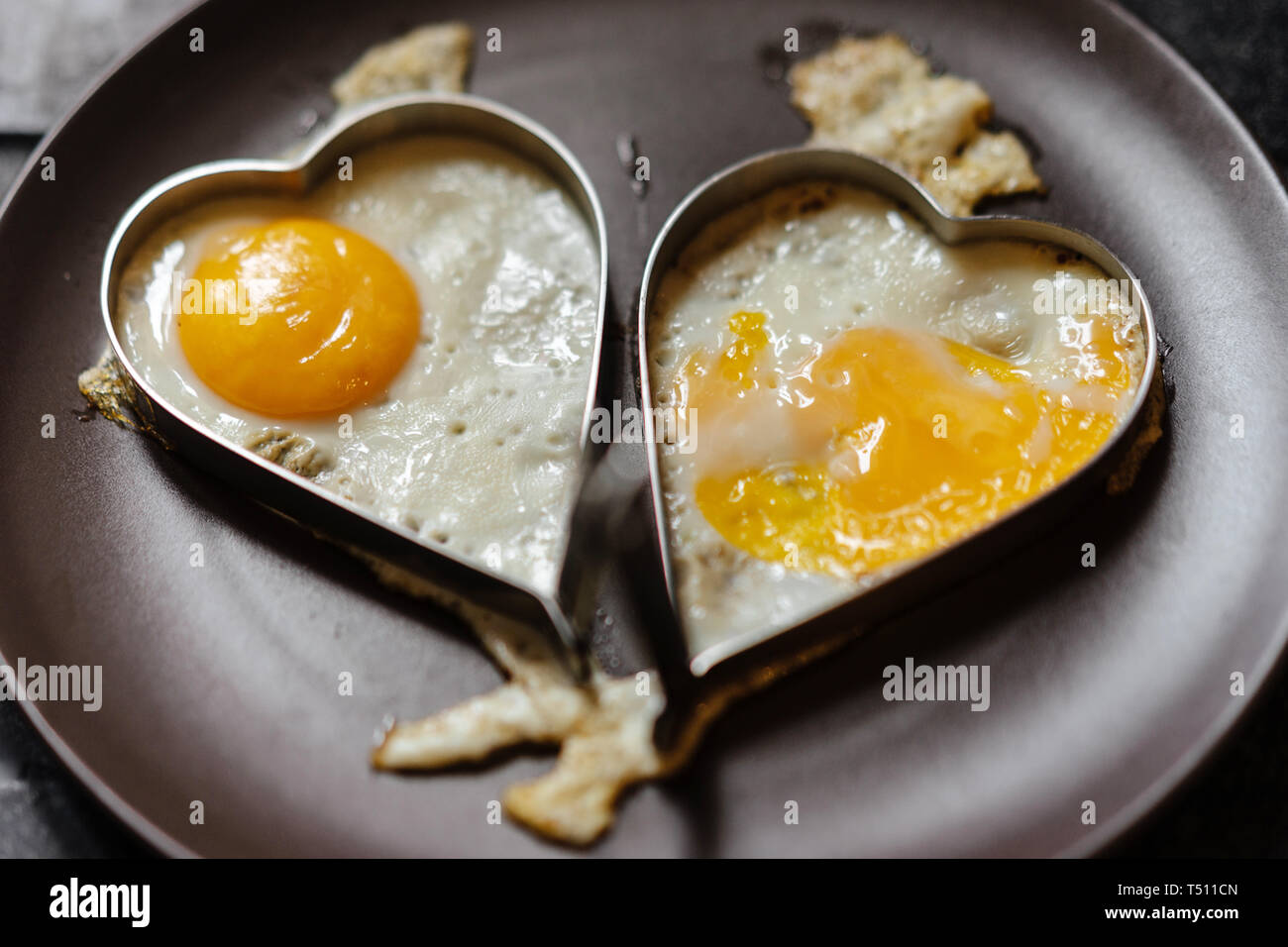 Oeufs brouillés dans deux cœurs. Thème de l'amour. Banque D'Images