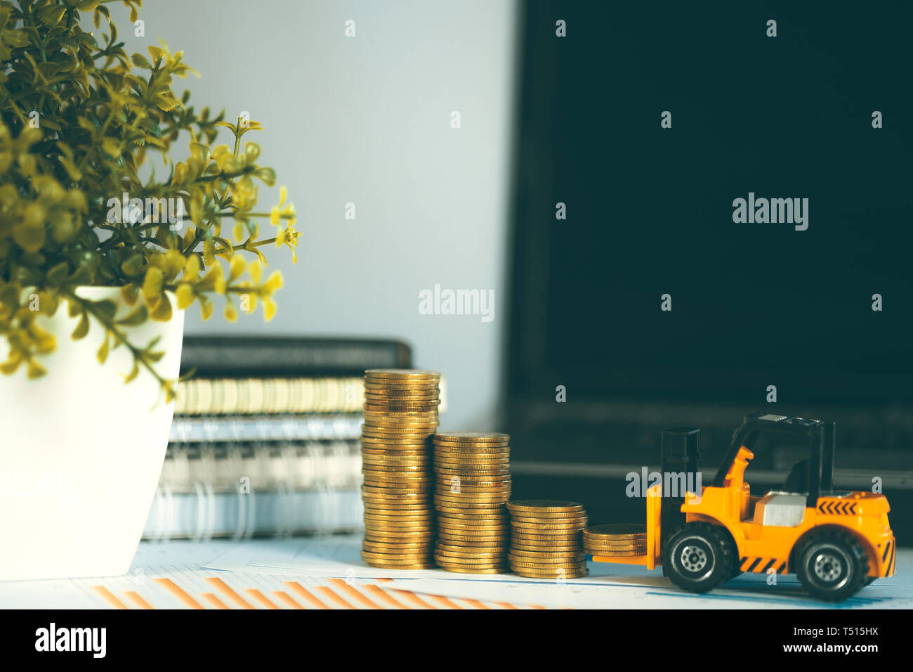 Mini miniature chariot avec une pile de pièces de monnaie sur la table de travail avec des fournitures de bureau ou du travail de bureau outils essentiels pour les éléments financiers d'affaires concep Banque D'Images
