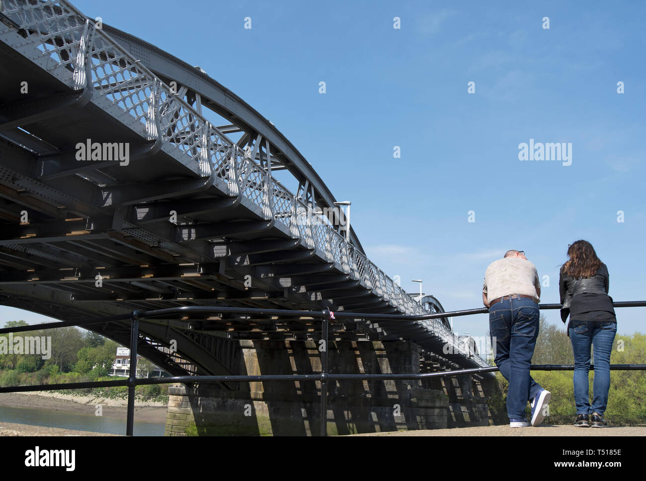 L'homme et la femme s'appuyer sur les rails près de Barnes, pont sur la tamise dans Barnes, Londres, Angleterre Banque D'Images