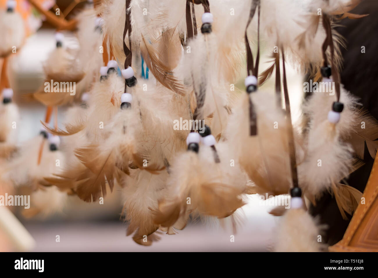 Amulettes de plumes blanches avec des cordes de couleur accroché sur le marché pour la vente Banque D'Images