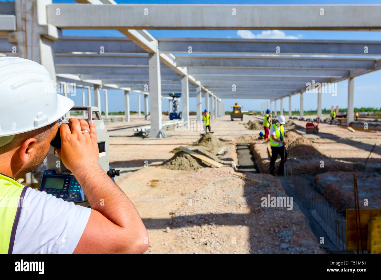 Ingénieur inspecteur est la mesure de niveau sur site de construction. Les géomètres s'assurer des mesures précises avant d'entreprendre de grands projets de construction. Banque D'Images