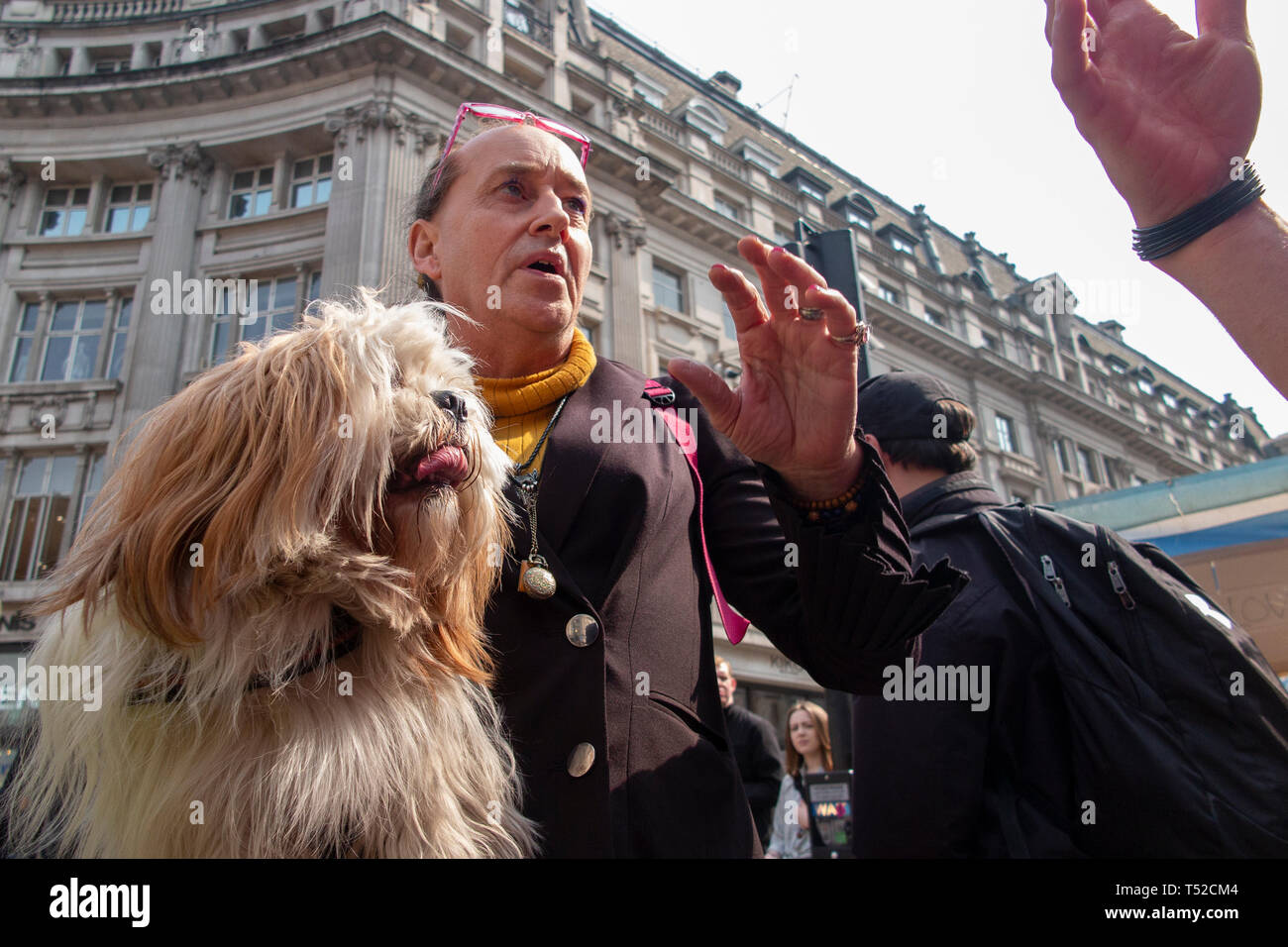 Une croix s'habiller activiste environnemental de l'Extinction du mouvement de rébellion à Londres Oxford Circus débats la cause avec un passant par Banque D'Images