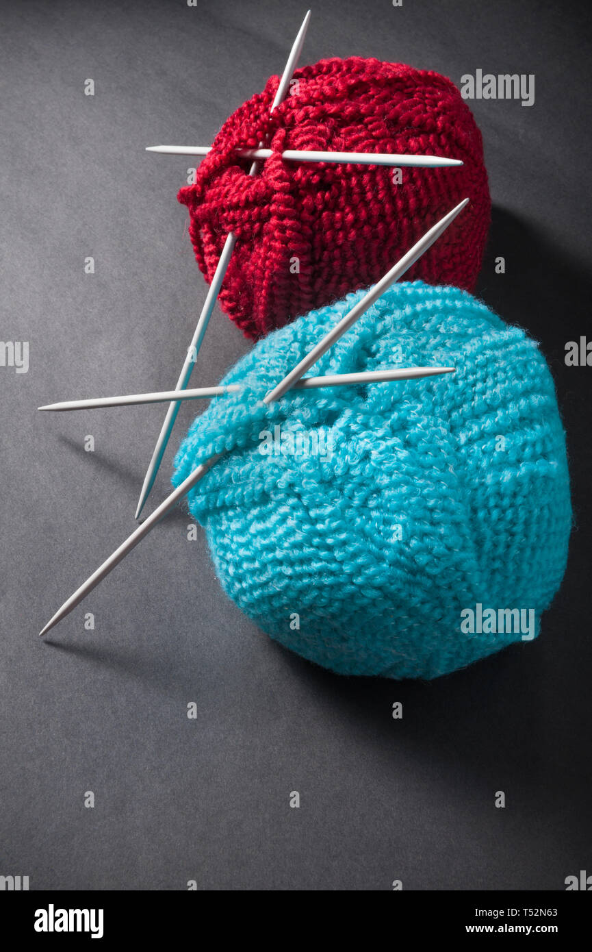 Balle de laine et des aiguilles à tricoter sur fond sombre Banque D'Images