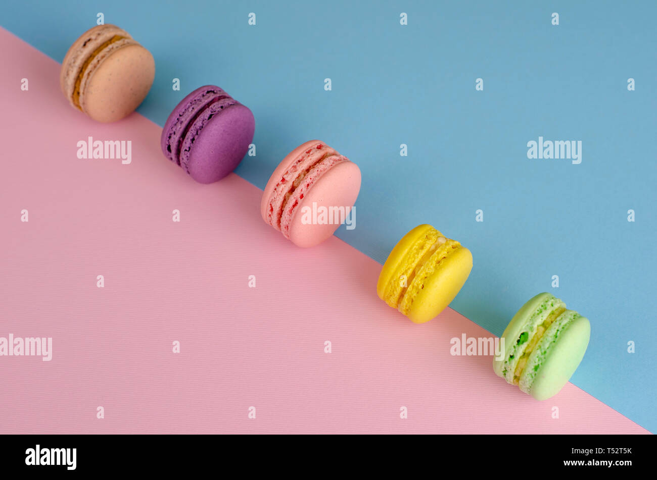 Sweet cookies colorés ou macarons macarons sur fond coloré couleurs pastel. Copier l'espace. Délicieux dessert français concept. Banque D'Images