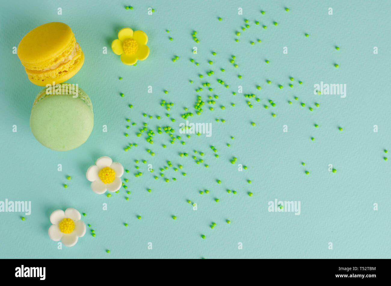 Jaune et vert ou macarons macarons sur fond de menthe pastel décorées de Nutrifer et frowers de mastic . L'espace pour le texte. Message d'accueil ou invitati Banque D'Images