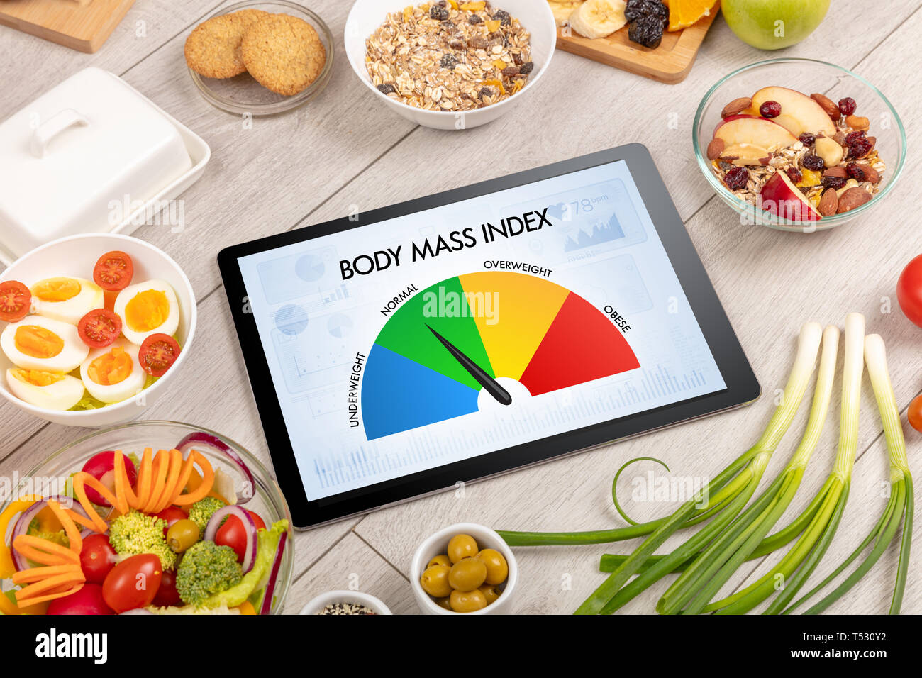 L'alimentation saine avec tablette sur un fond de bois avec des mots de masse corporelle. Concept de santé. Banque D'Images