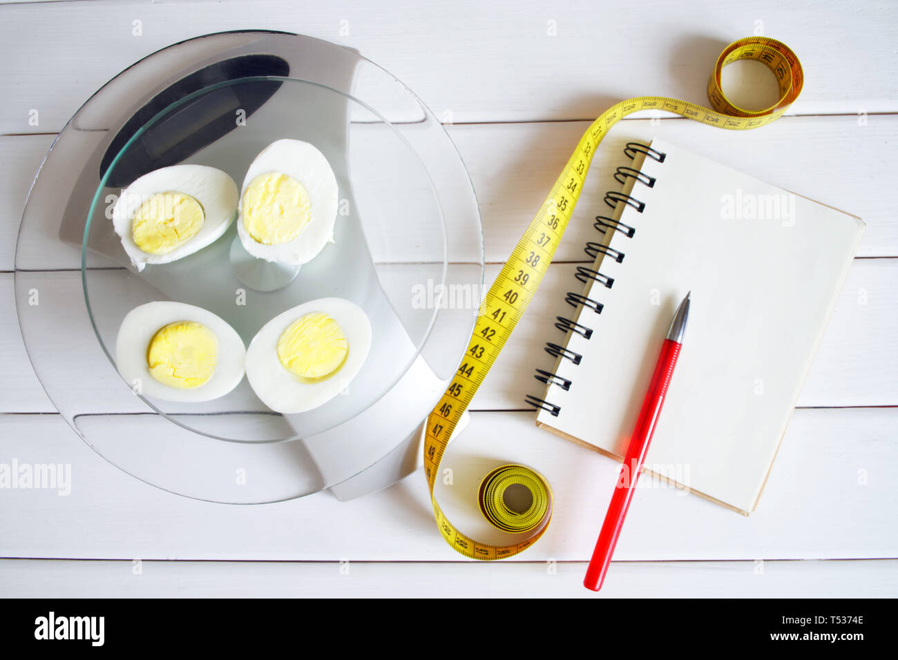 La quantité de protéines, de calories, de glucides et de graisses dans les aliments. Couper oeuf sur la balances de cuisine. Slim figure, fitness, perte de poids, l'alimentation et l'écrou adéquat Banque D'Images