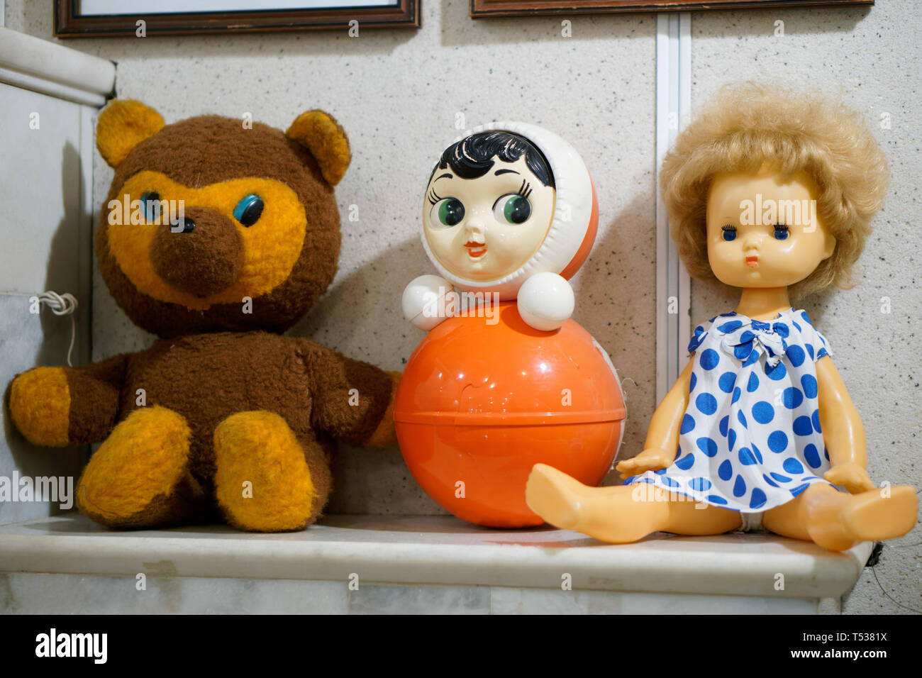 Old vintage jouets pour enfants - une poupée, un ours et un gobelet sur une cheminée. L'objet du passé. Banque D'Images