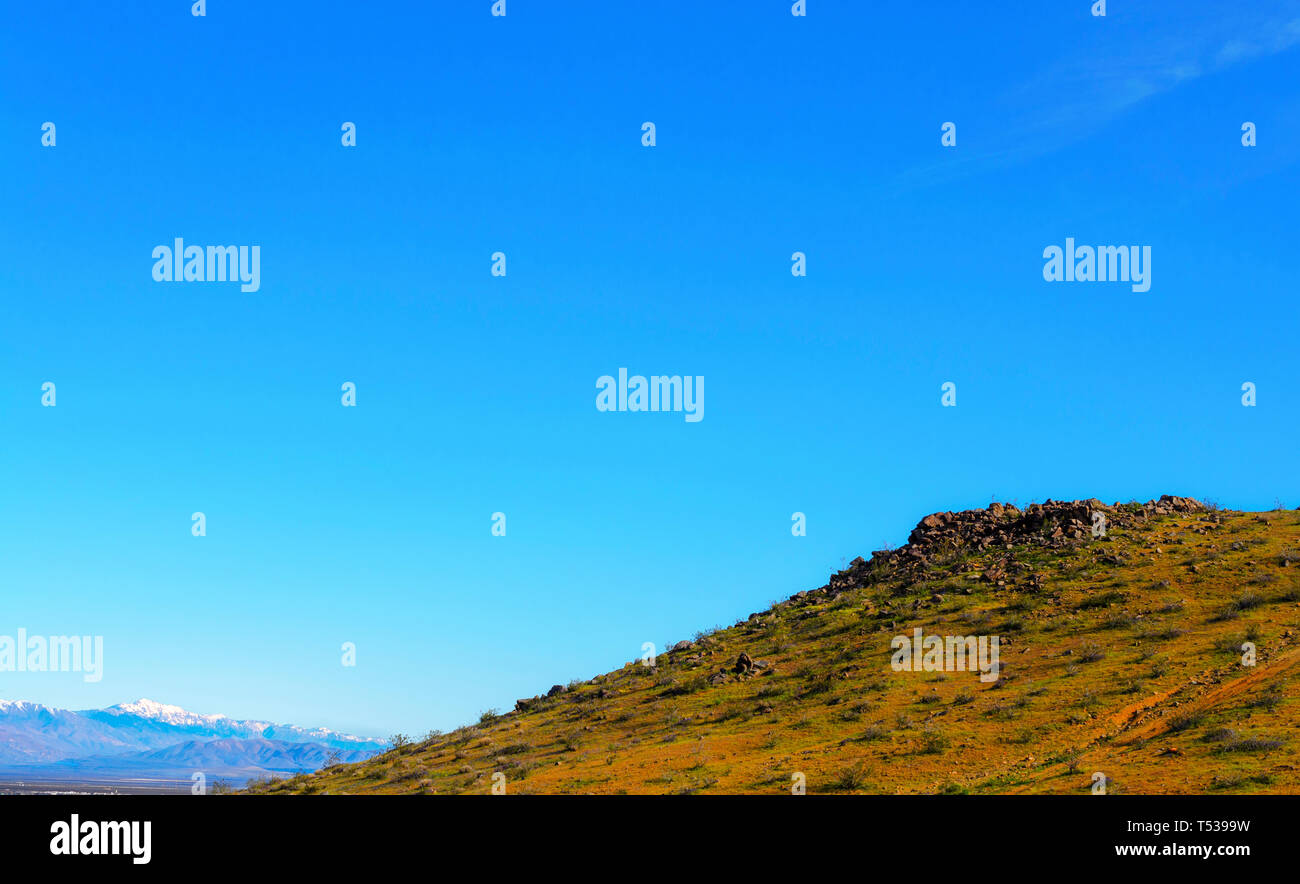 Télévision top hill avec des fleurs jaunes sur côté colline et rochers autour de la partie supérieure de la colline sous le ciel bleu. Banque D'Images