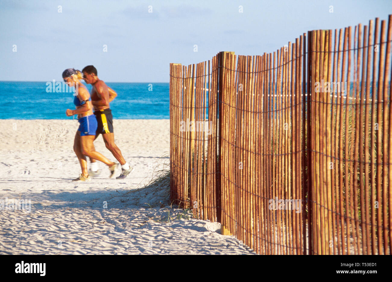 Miami Beach Florida, Atlantic Shore jogging couple, adulte adultes homme hommes, femme femme femme dame, passe clôture, frontière, frontière, protection naturelle du Banque D'Images