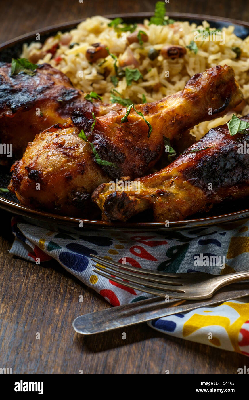 Cuisine africaine les jambes de poulet grillé avec riz jollof avec l'orzo et Black Eyed Peas Banque D'Images