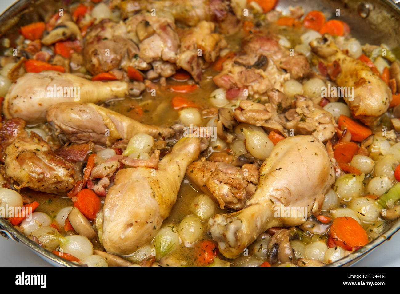 La cuisine française Coq au Vin avec ragoût de champignons crimini oignons perles et les carottes dans une sauce au vin blanc Banque D'Images