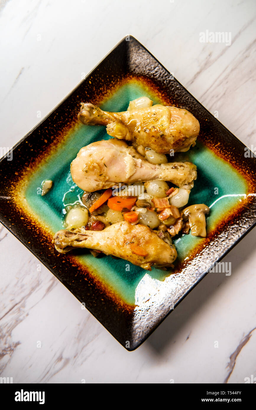 La cuisine française Coq au Vin avec ragoût de champignons crimini oignons perles et les carottes dans une sauce au vin blanc Banque D'Images