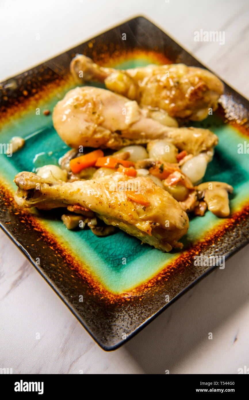 La cuisine française Coq au Vin avec ragoût de champignons crimini oignons perles et les carottes dans une sauce au vin blanc Banque D'Images
