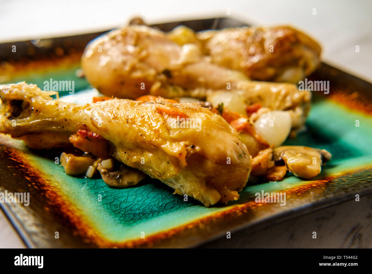 La cuisine française Coq au Vin avec ragoût de champignons crimini oignons perles et les carottes dans une sauce au vin blanc Banque D'Images