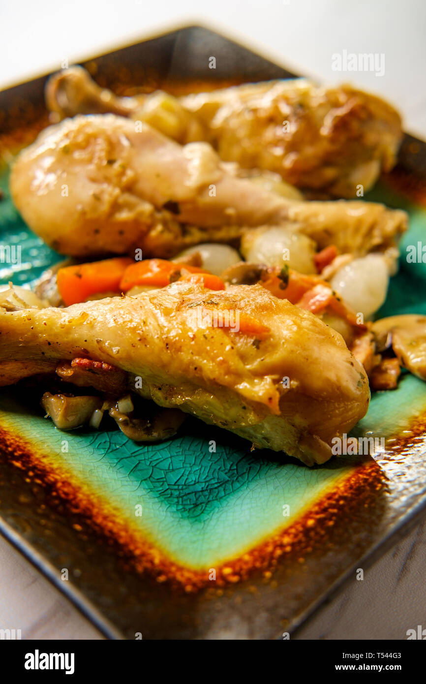 La cuisine française Coq au Vin avec ragoût de champignons crimini oignons perles et les carottes dans une sauce au vin blanc Banque D'Images