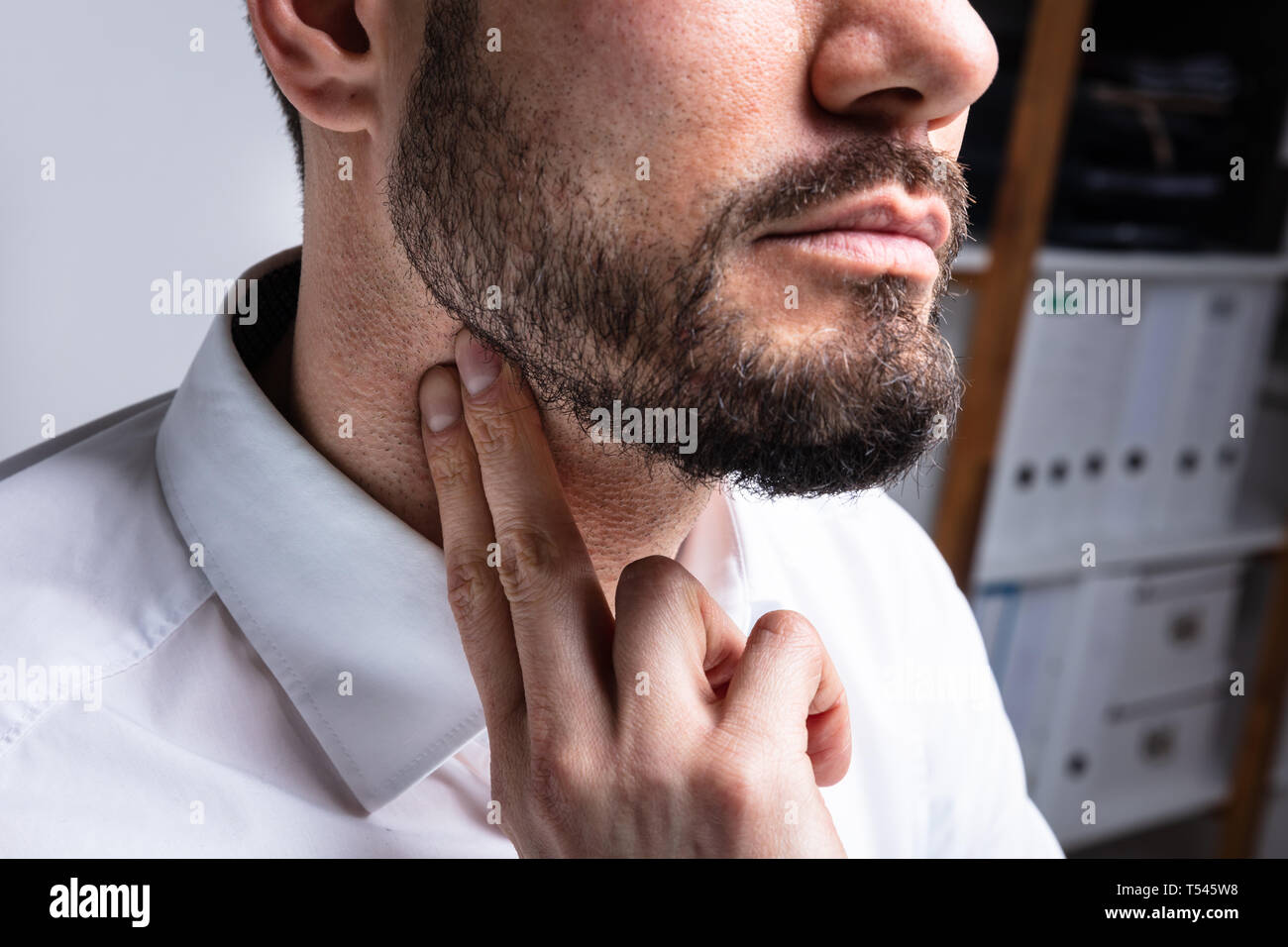 Portrait de jeune homme de toucher son cou pour éliminer la haute pression sanguine Banque D'Images