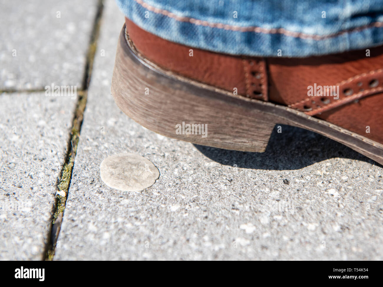 Gelsenkirchen, Allemagne. Apr 16, 2019. ILLUSTRATION - Une femme essaie de ne pas faire un pas sur un vieux chewing-gum craché avec sa chaussure. De nombreuses villes sont à discuter des amendes pour chewing-gum qui a été loin de naissain. Chewing-gums, mégots, dog poo : dans les centres-villes, beaucoup de choses finissent par négligemment dans la rue. Certaines municipalités dans le sud-ouest prennent des mesures avec des peines plus sévères et des campagnes anti-gaspillage. (Dpa : "Les villes lutte contre les pécheurs - frais élevés devrait dissuader') Crédit : Caroline Seidel/dpa/Alamy Live News Banque D'Images