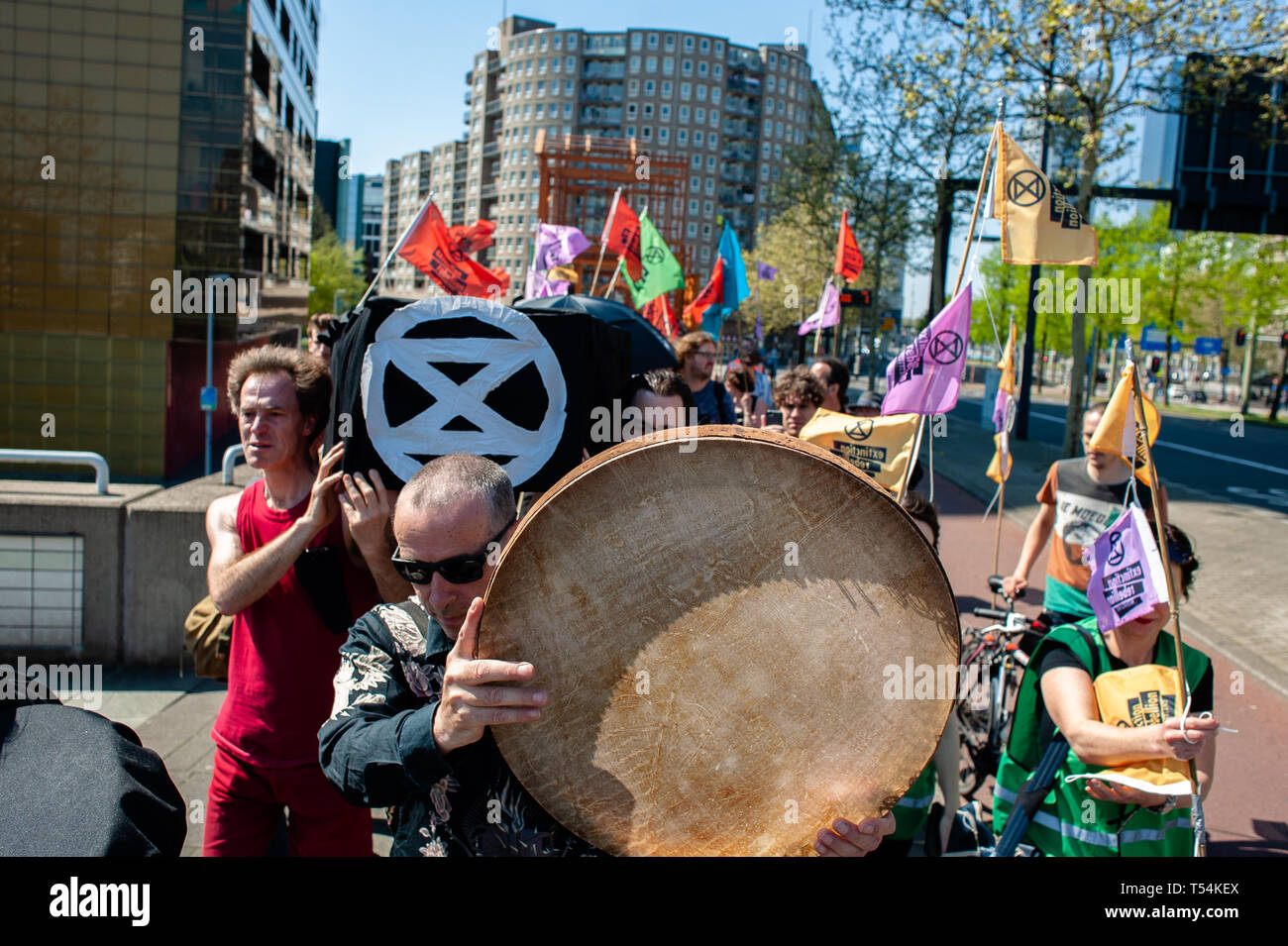 Rotterdam, Pays-Bas. Apr 20, 2019. Un groupe de militants sont vus portant un cercueil tout en jouant bodhrans lors de la manifestation. Un cortège funéraire a été réalisée par le mouvement international, l'extinction de rébellion à Rotterdam. Avec cette action, le mouvement est exigeant le gouvernement néerlandais à déclarer une loi d'urgence climatique sur l'élaboration d'un plan Delta Climat pour Rotterdam, un bilan net de zéro émission de CO2 en 2025, y compris le Port de Rotterdam. Credit : SOPA/Alamy Images Limited Live News Banque D'Images