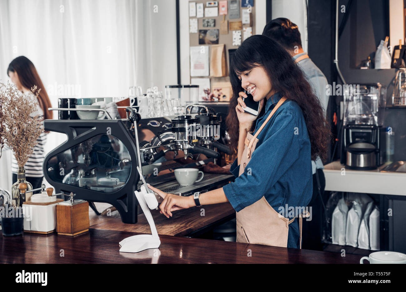 Barista asiatiques utiliser comprimé se commande de client dans un café, café propriétaire écrit à boire bar comptoir,Nourriture et boisson concept d'entreprise, le Service Banque D'Images