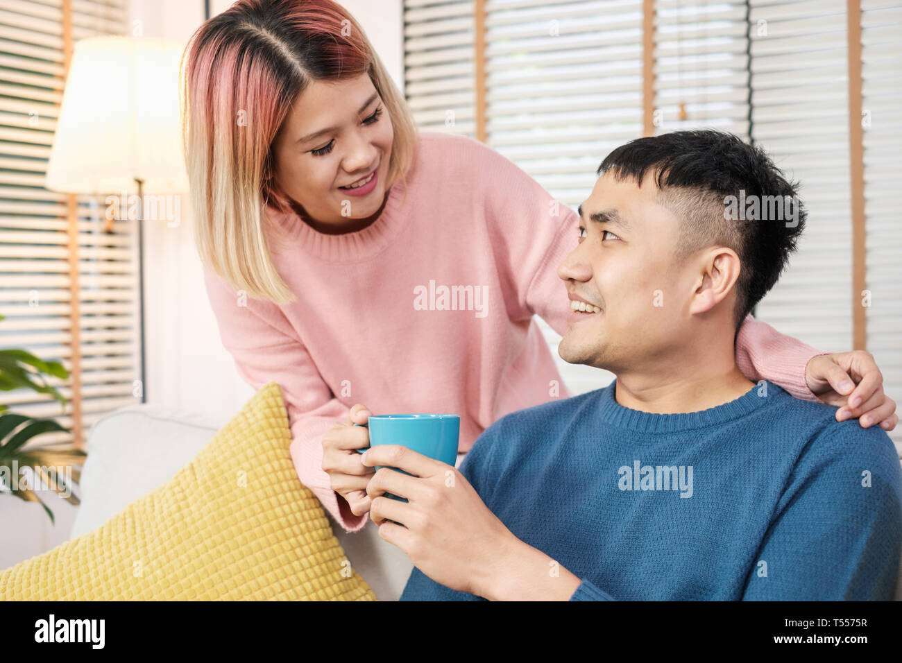 Happy asian couple assis à boire du café sofa dans chambre.En couple amoureux accueil concept Banque D'Images