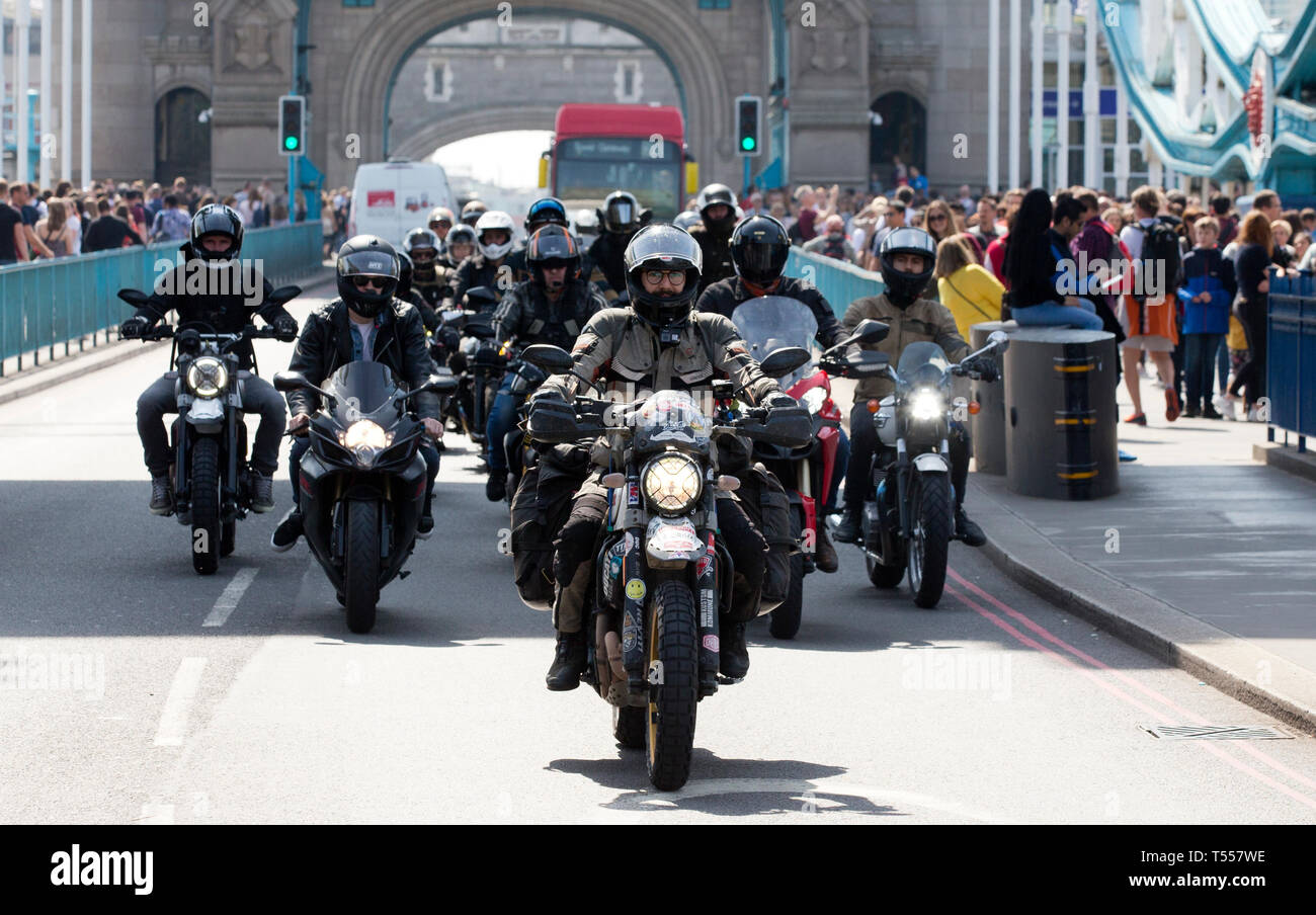 De 0001 sous embargo Lundi 22 avril Henry Crew (centre) et de supports arrivent sur le Tower Bridge à Londres en tant qu'il casse record mondial Guinness pour devenir la plus jeune personne à faire le tour du monde sur une moto. Henry, de Petersfield dans Surrey, a commencé son voyage en avril 2018 et a voyagé dans 35 pays et plus de 35 000 miles, la collecte de fonds pour la Fondation Movember. Banque D'Images