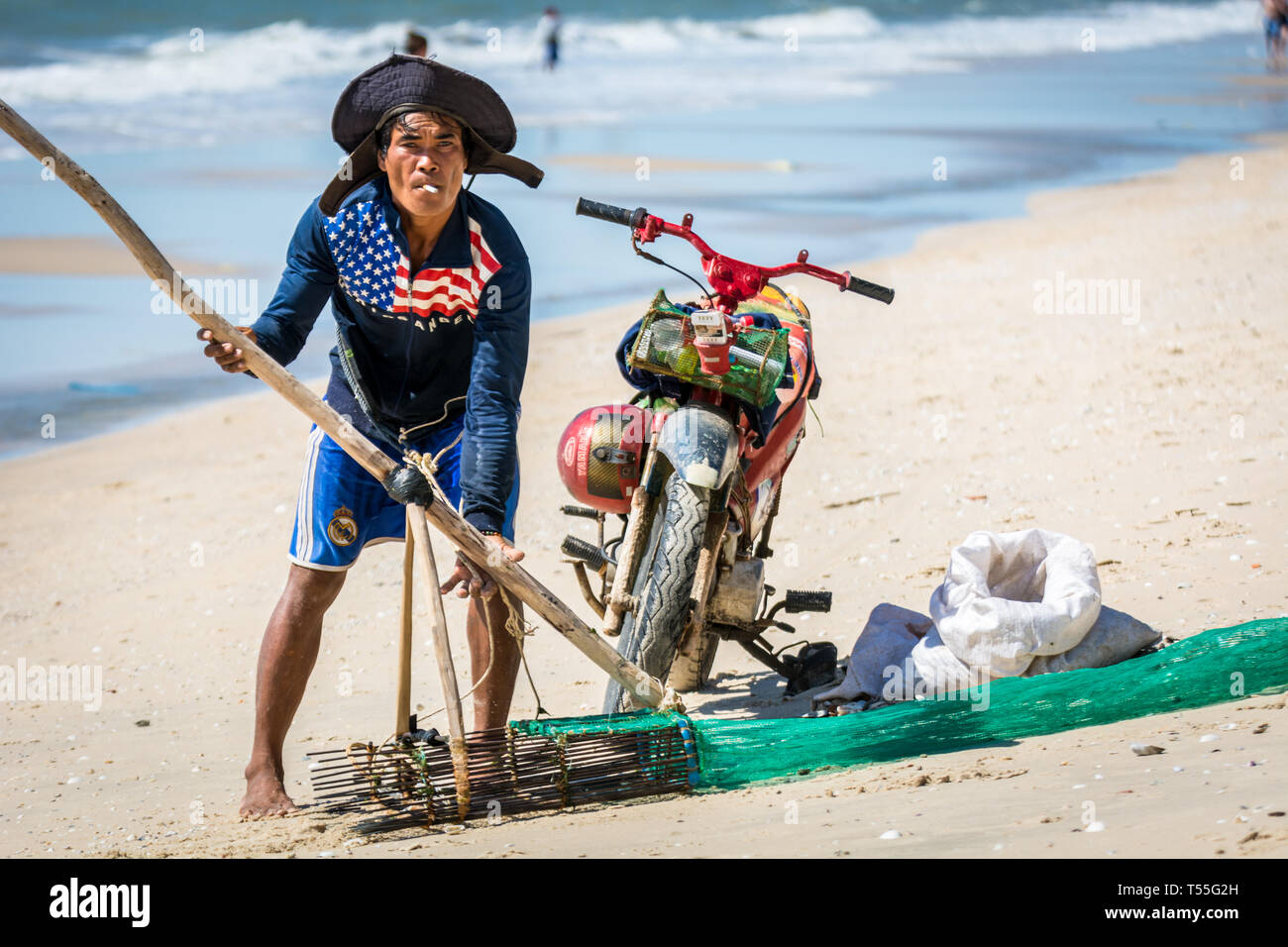 Pêcheur vietnamien collectant des coquillages sur la plage.Voyage Vietnam huîtres collectrices locales Banque D'Images