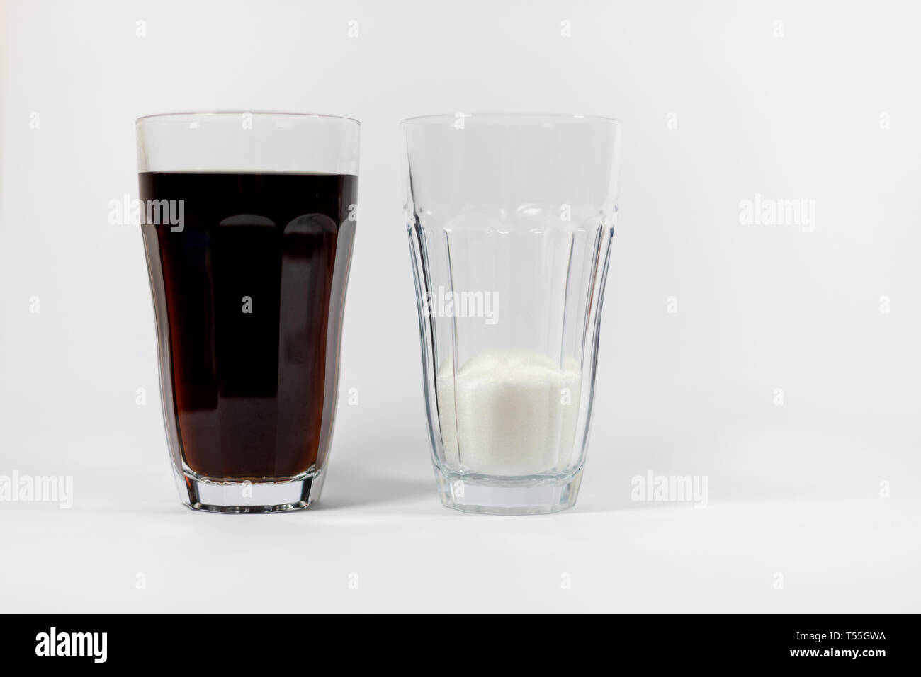 Un verre de coca et un verre de sucre montrant le visual quantité de sucre  contenu dans le coca, situé sur un fond blanc Photo Stock - Alamy