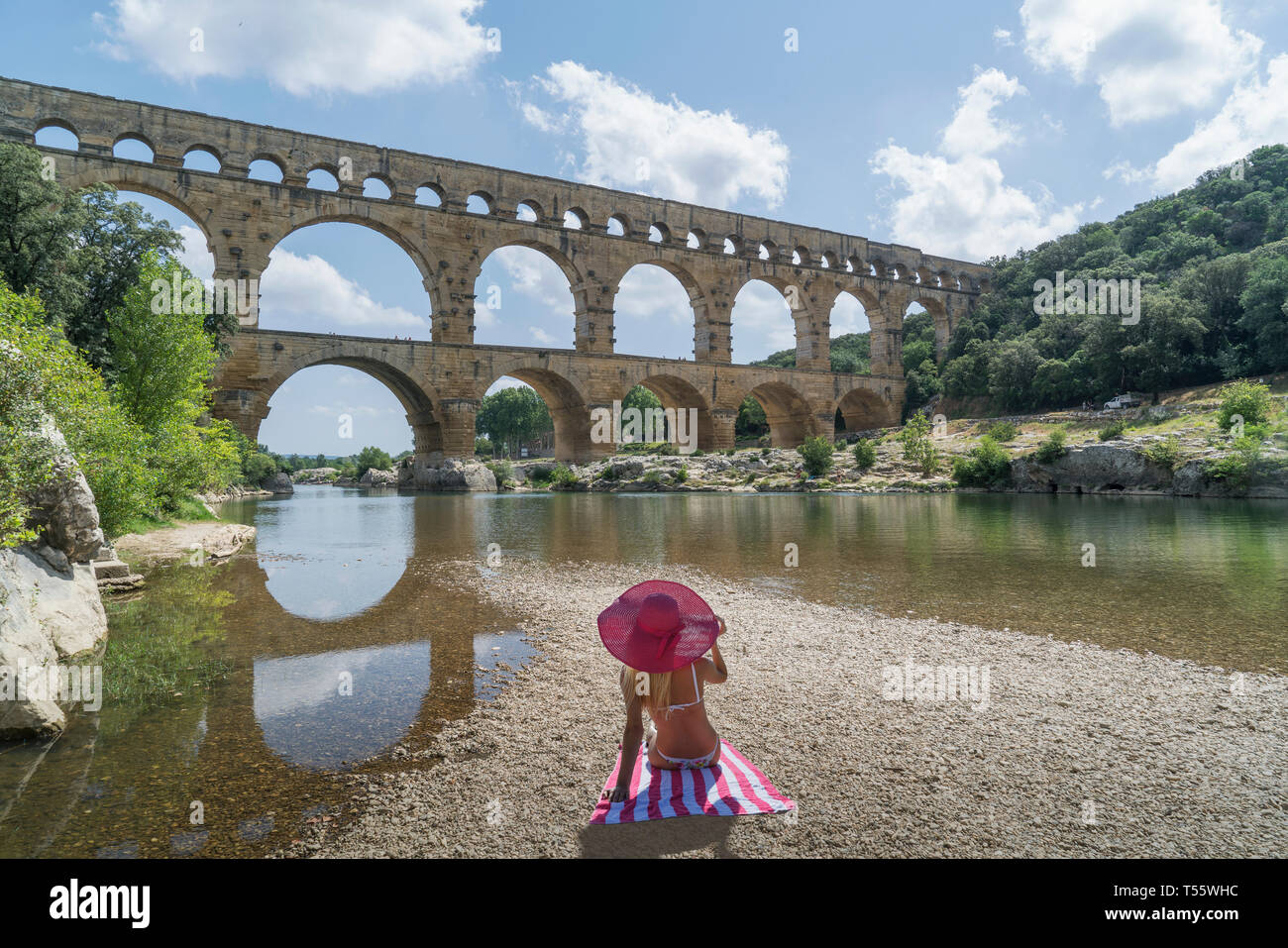 Femme portant chapeau de soleil rose par Pont du Gard à Castillon-du-Gard, France Banque D'Images