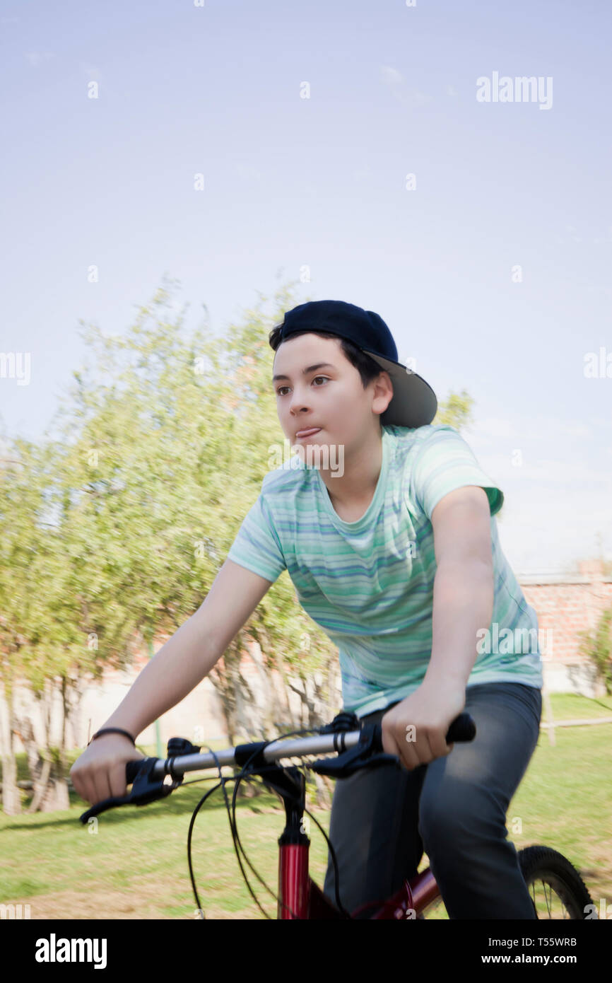 Teenage boy à vélo dans park Banque D'Images