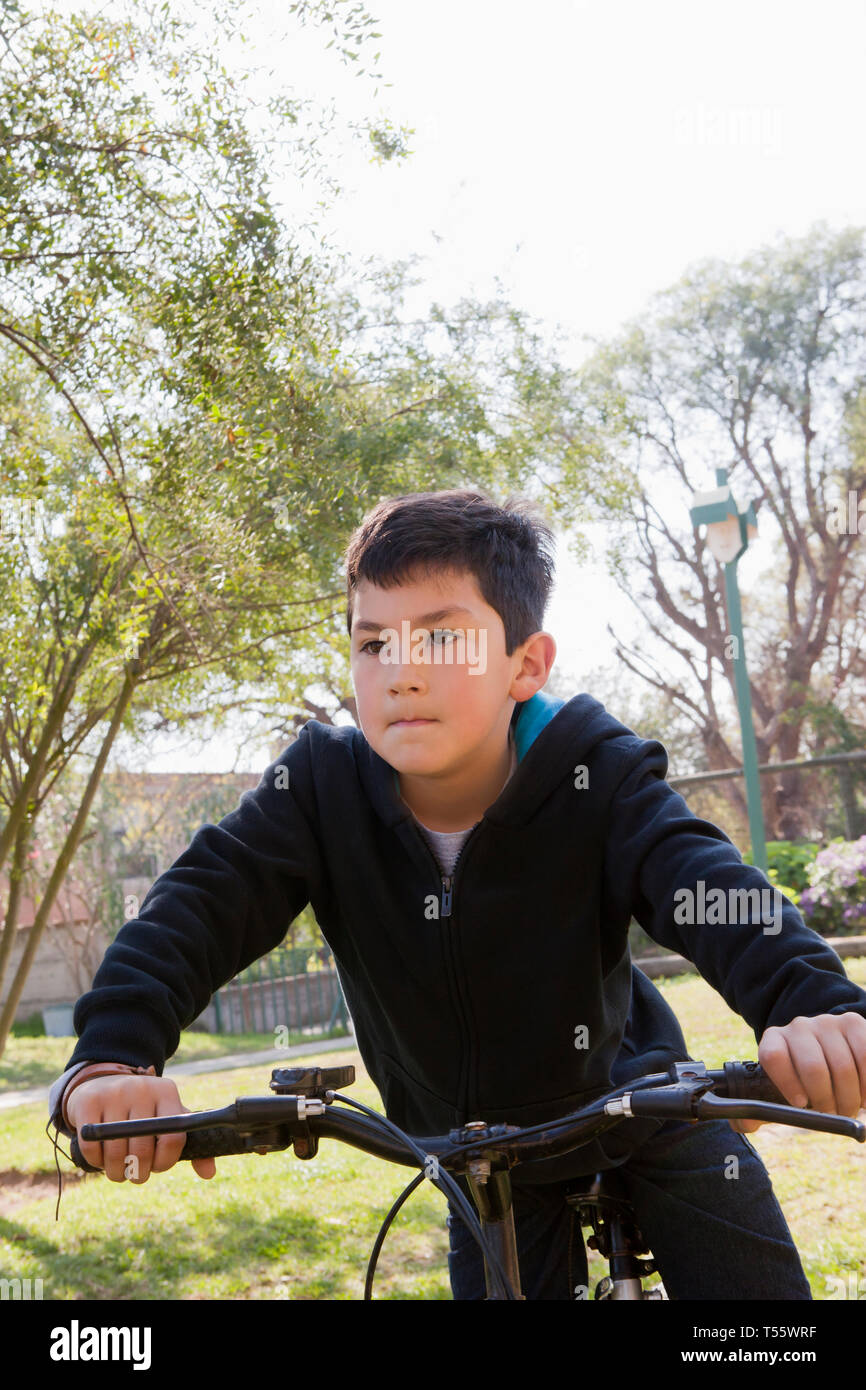 Boy riding bicycle in park Banque D'Images