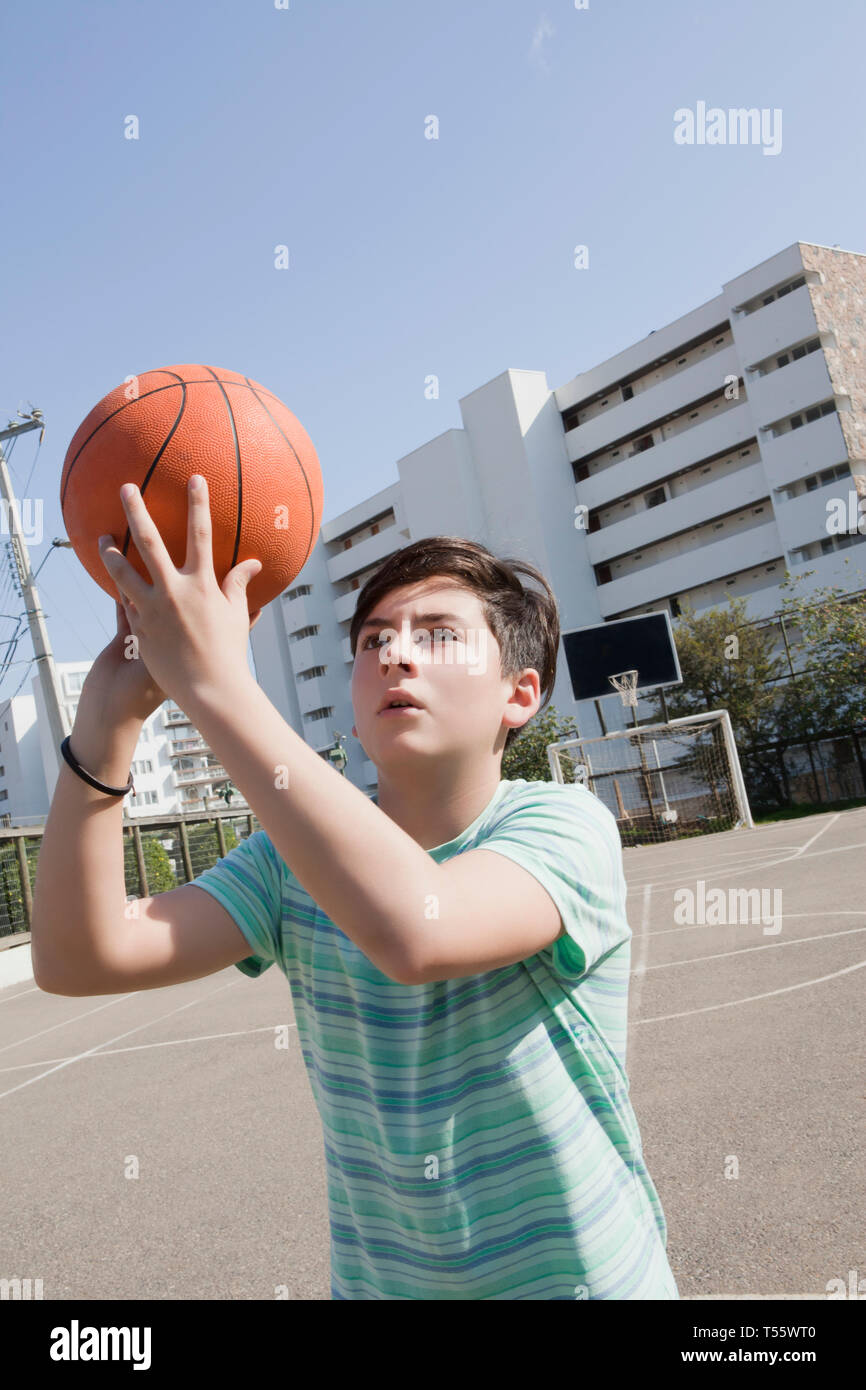 Teenage boy holding basketball Banque D'Images