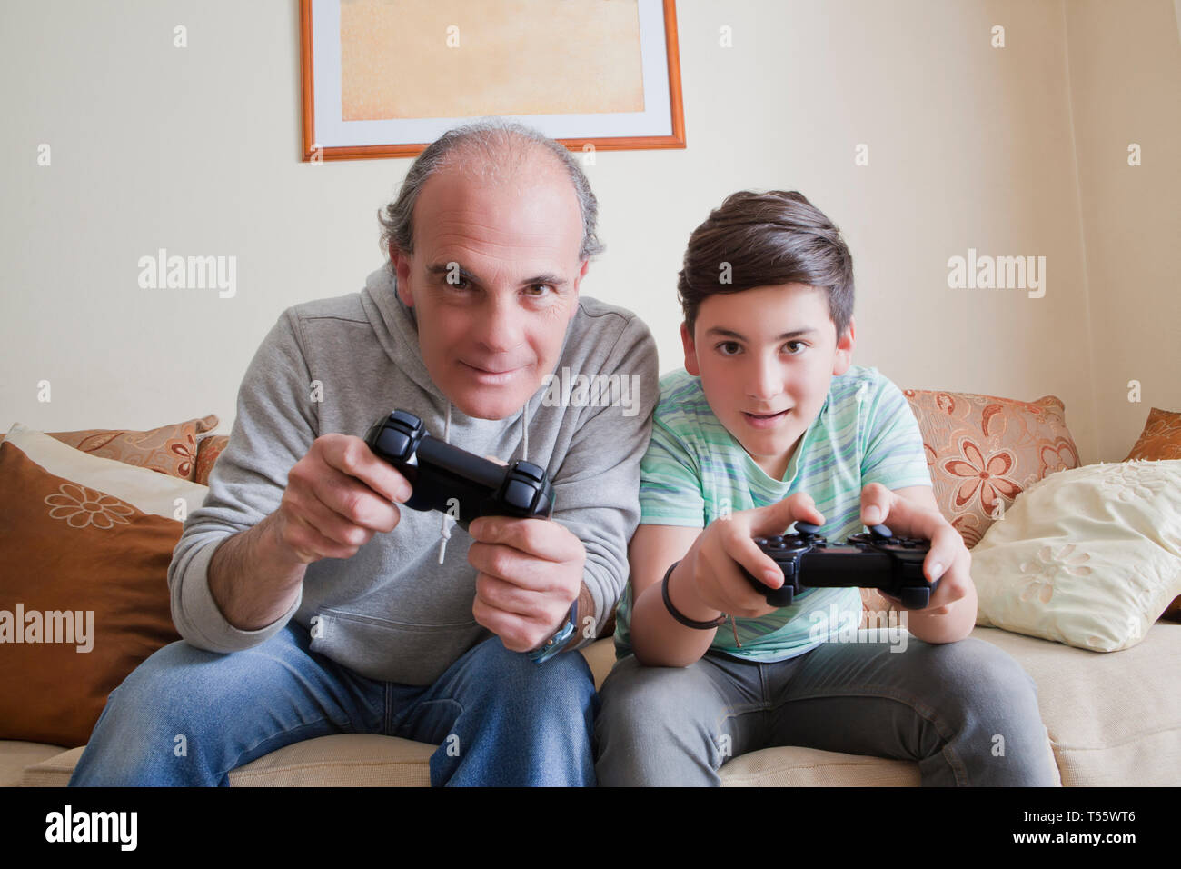 Père et fils adolescent playing video game Banque D'Images