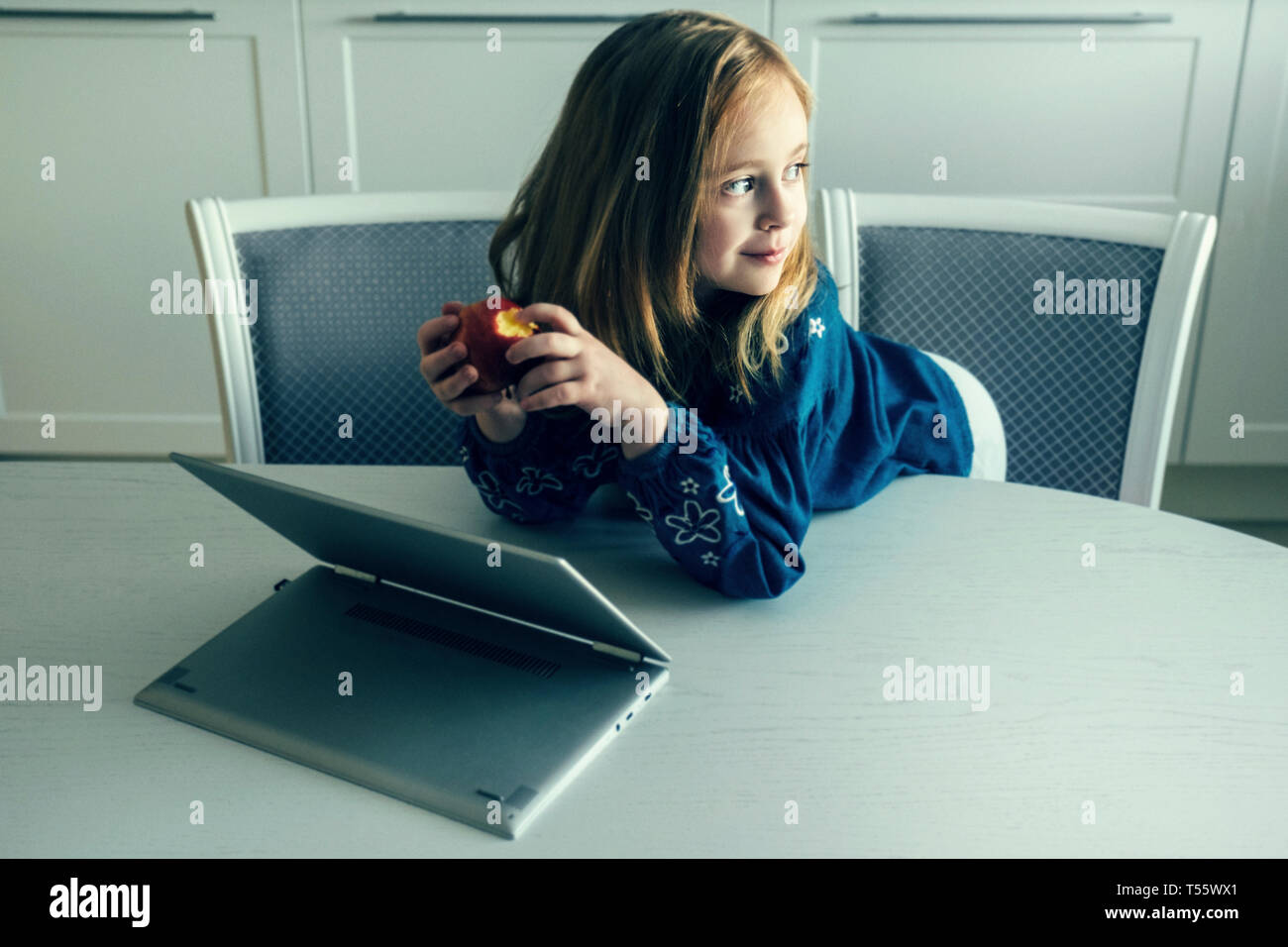 Girl leaning on table par l'ordinateur portable Banque D'Images